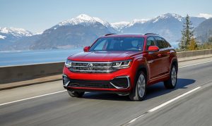 The 2021 Atlas Cross Sport driving with mountains behind it.